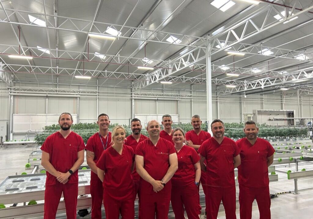 Group in red uniforms at industrial facility
